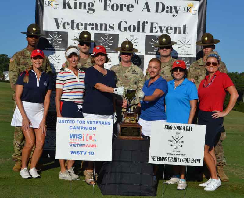 Military Service Members standing with lady golfers at a King Fore A Day charity golf tournament